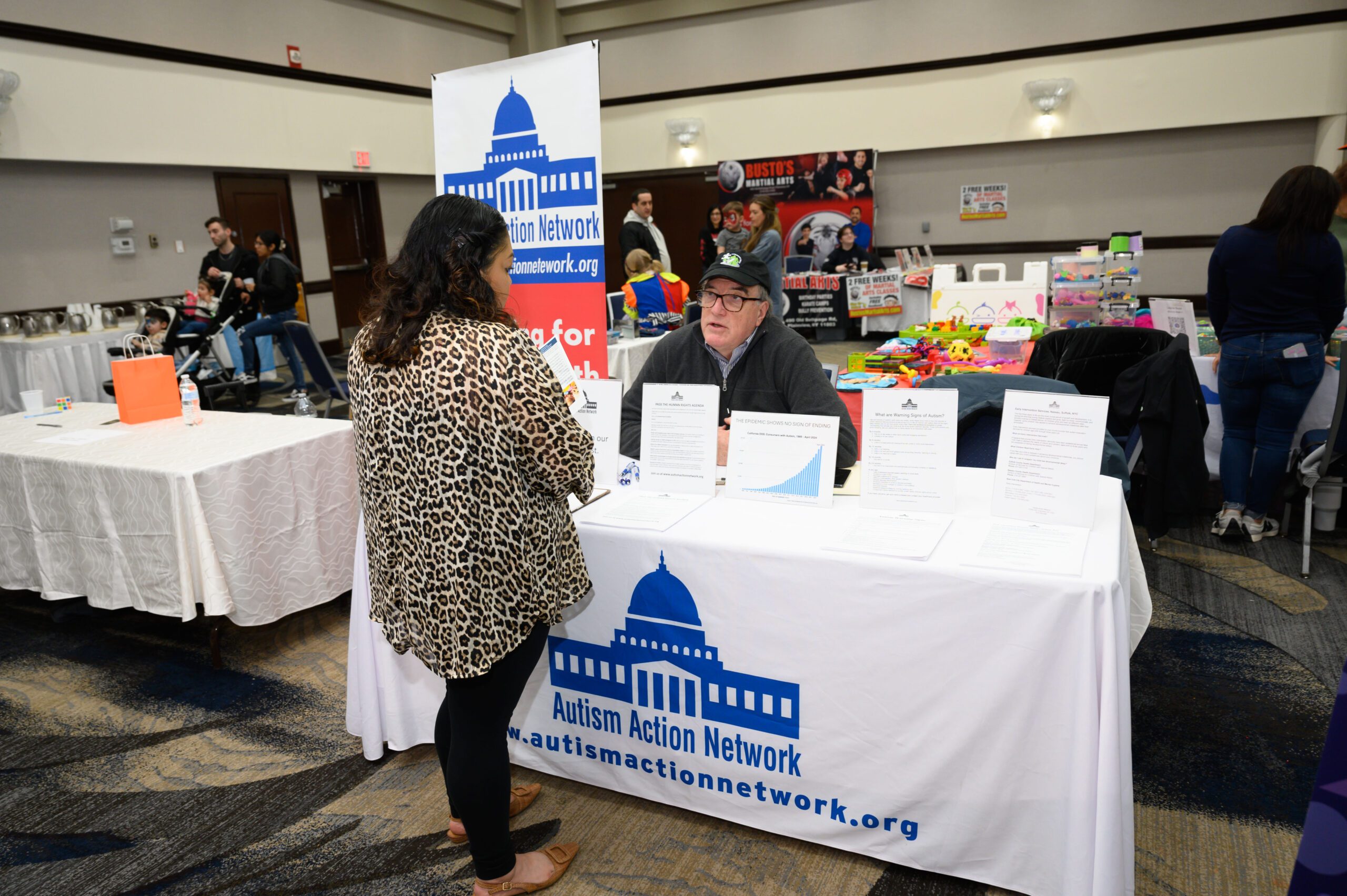 A representative from Autism Action Network speaks with an attendee