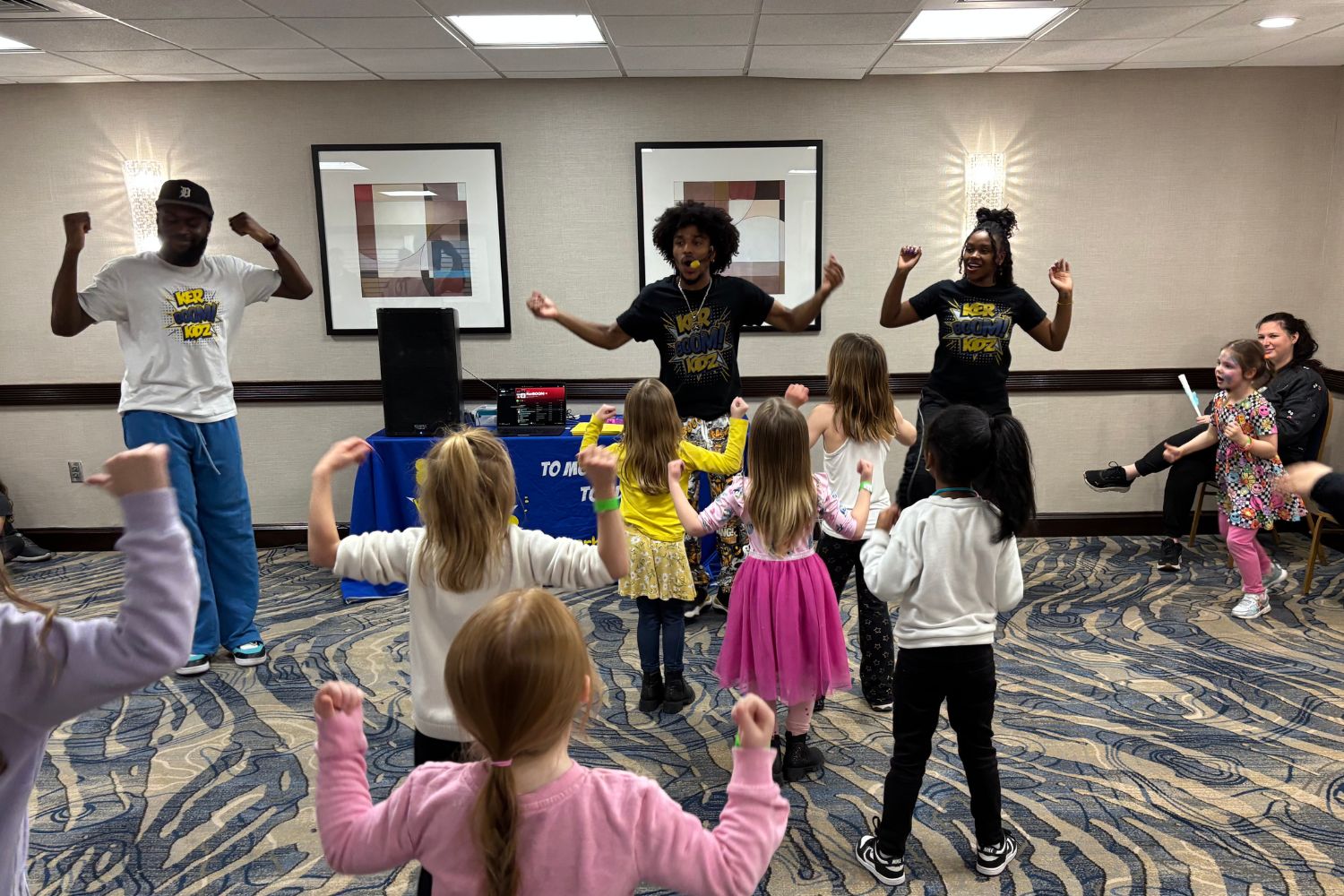 Instructors and children dance in a class
