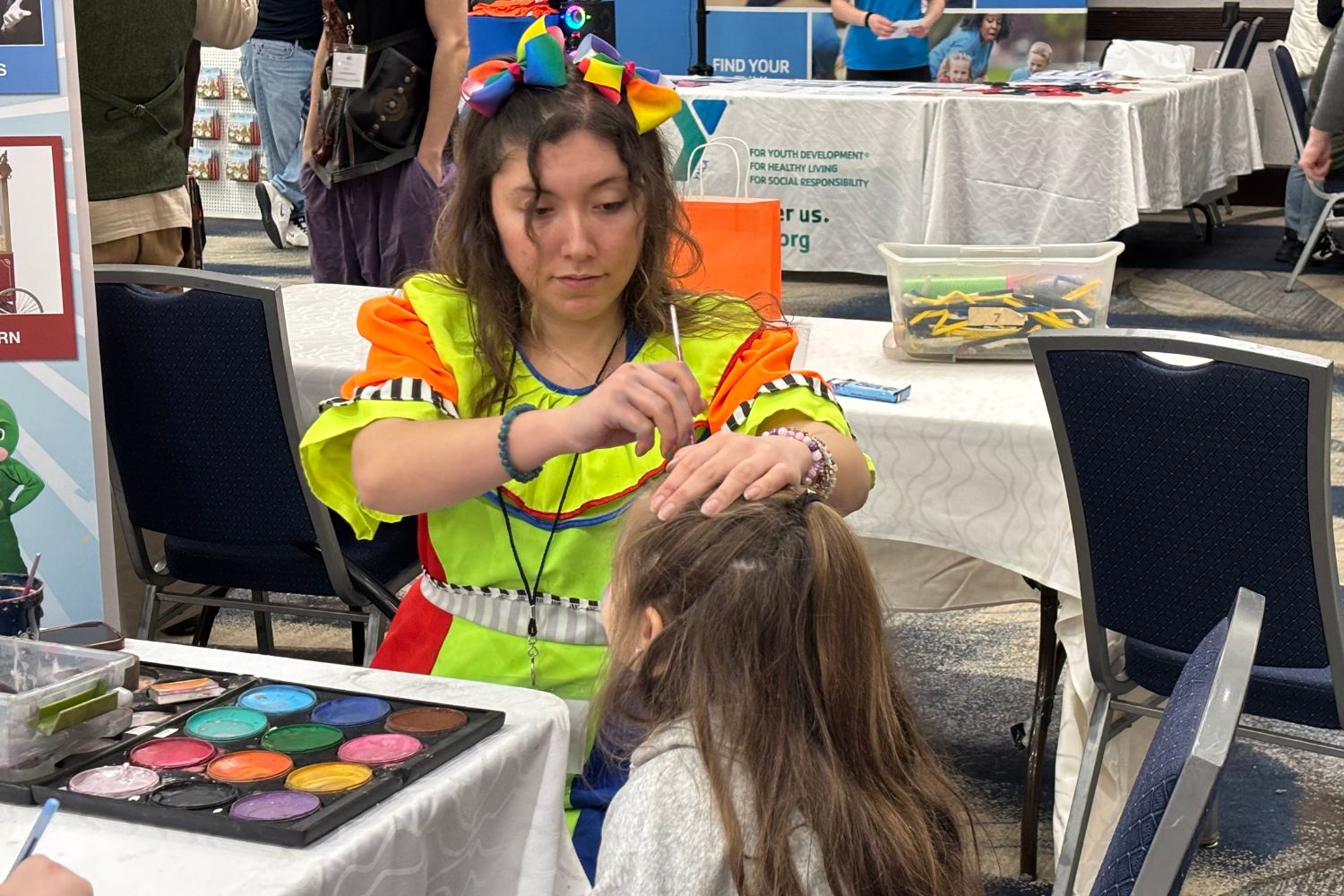A face painter paints a girl's face