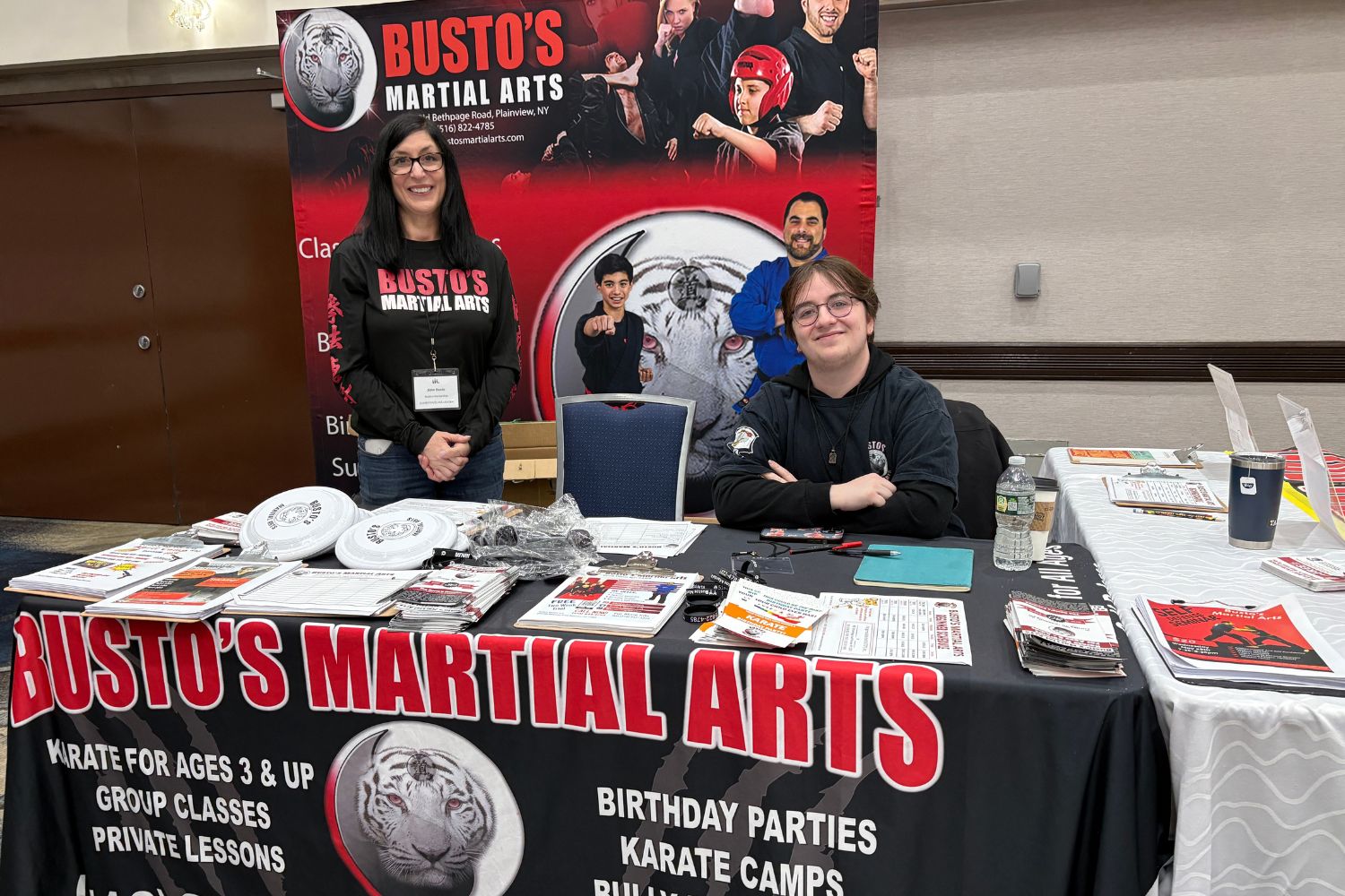 2 representatives from Busto's Martial Arts at their booth